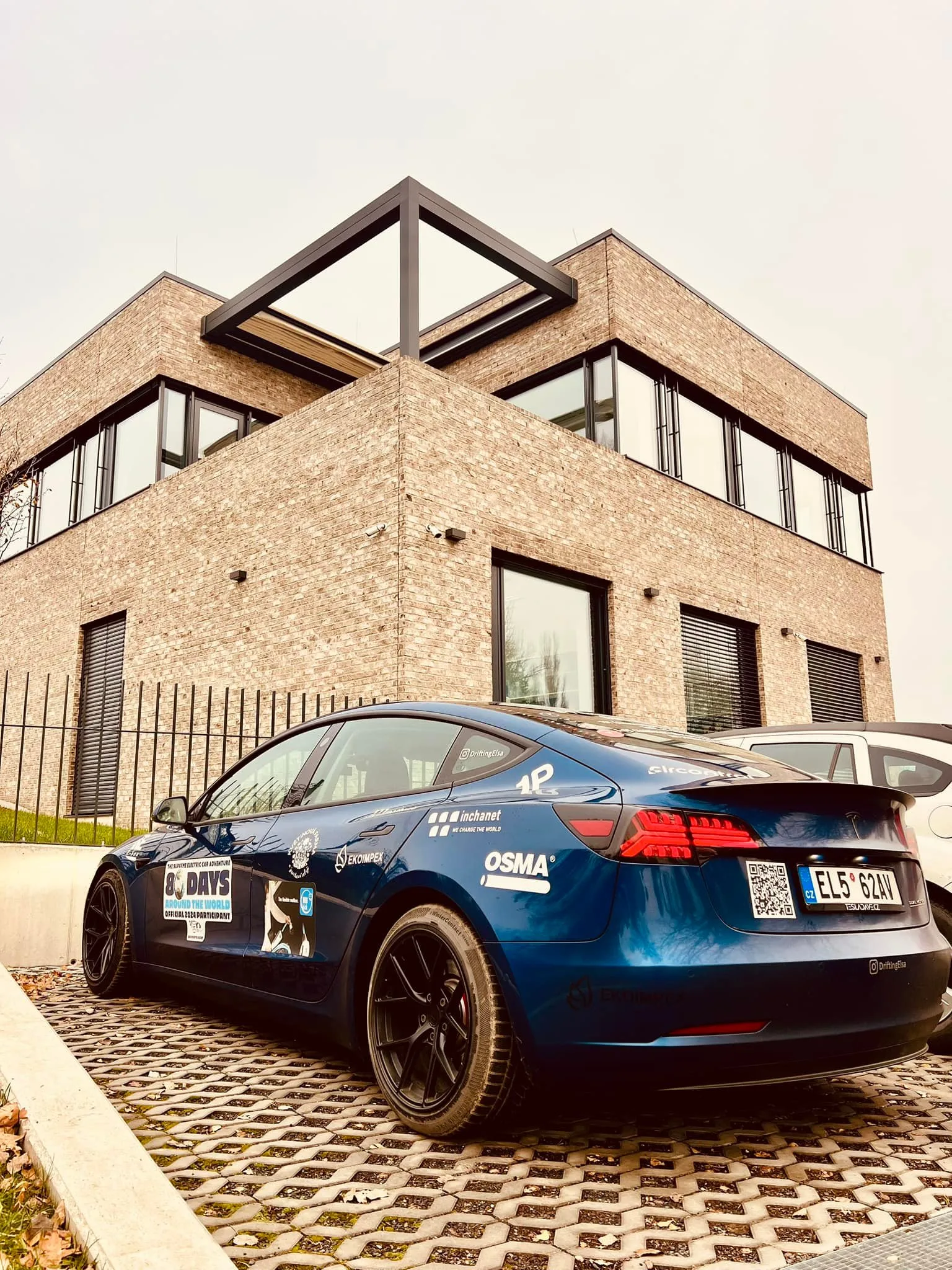 Tesla zaparkovaná před zubní klinikou Implanta po návratu z cesty, listopad 2024